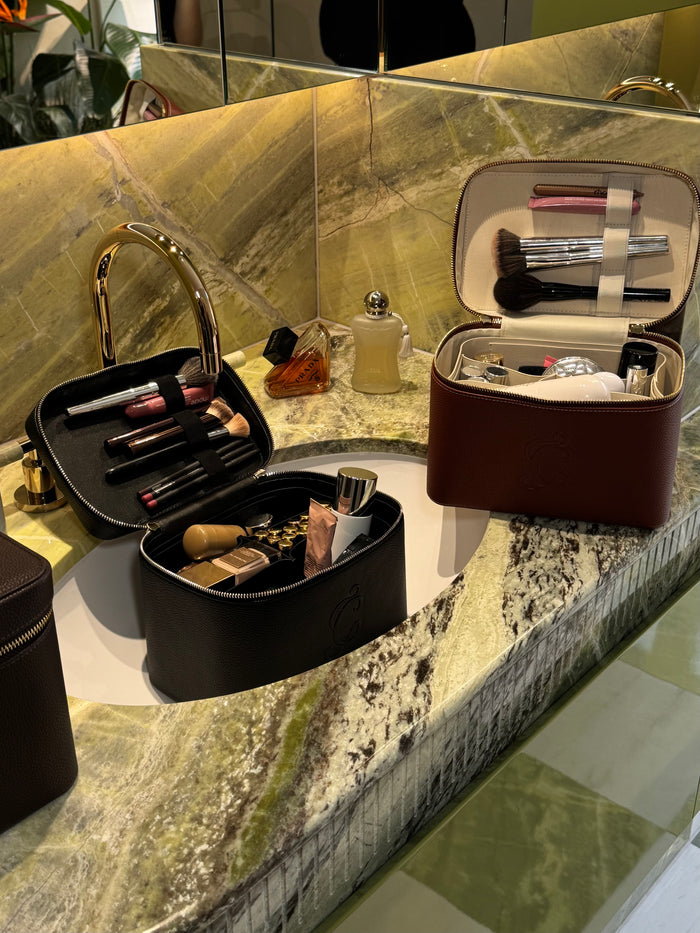 vegan leather makeup bags in bathroom, luxury cosmetic bags and travel vanity cases on counter